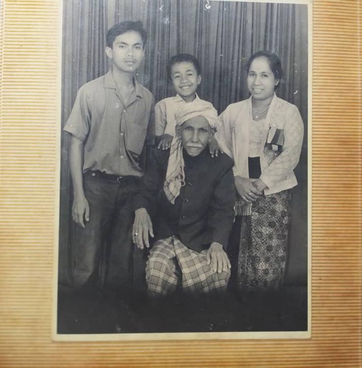 Foto hitam putih Haji Habib Arrasuli duduk dikelilingi anak dan cucunya